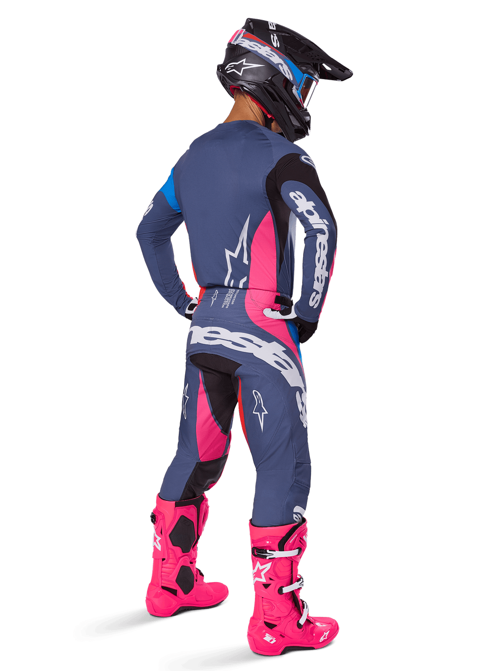 Motorcrossrijder van achteren gezien die een Alpinestars 2025 Techstar Dreem broek draagt, grijsblauw en magenta roze ontwerp met zwarte accenten, gedragen met een bijpassende jersey en felroze laarzen, atletische racepasvorm voor off-road prestaties.