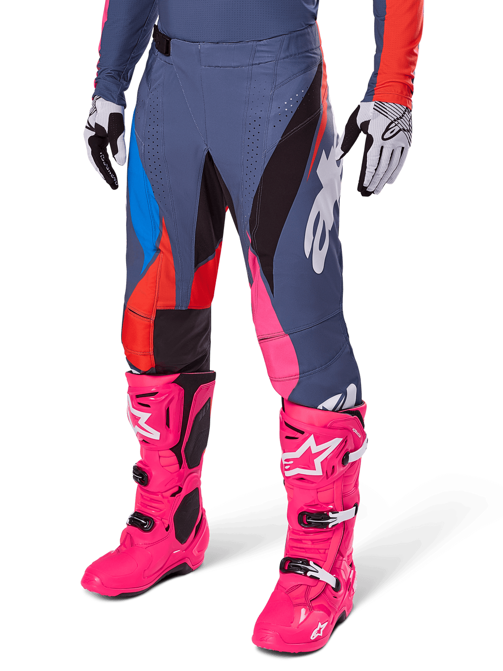 Alpinestars 2025 Techstar Dreem broek, motorcrossbroek, donkergrijs met blauwe, rode en roze panelen, witte graphics, gedragen met felroze laarzen en zwart-witte handschoenen, opvallend high-visibility ontwerp