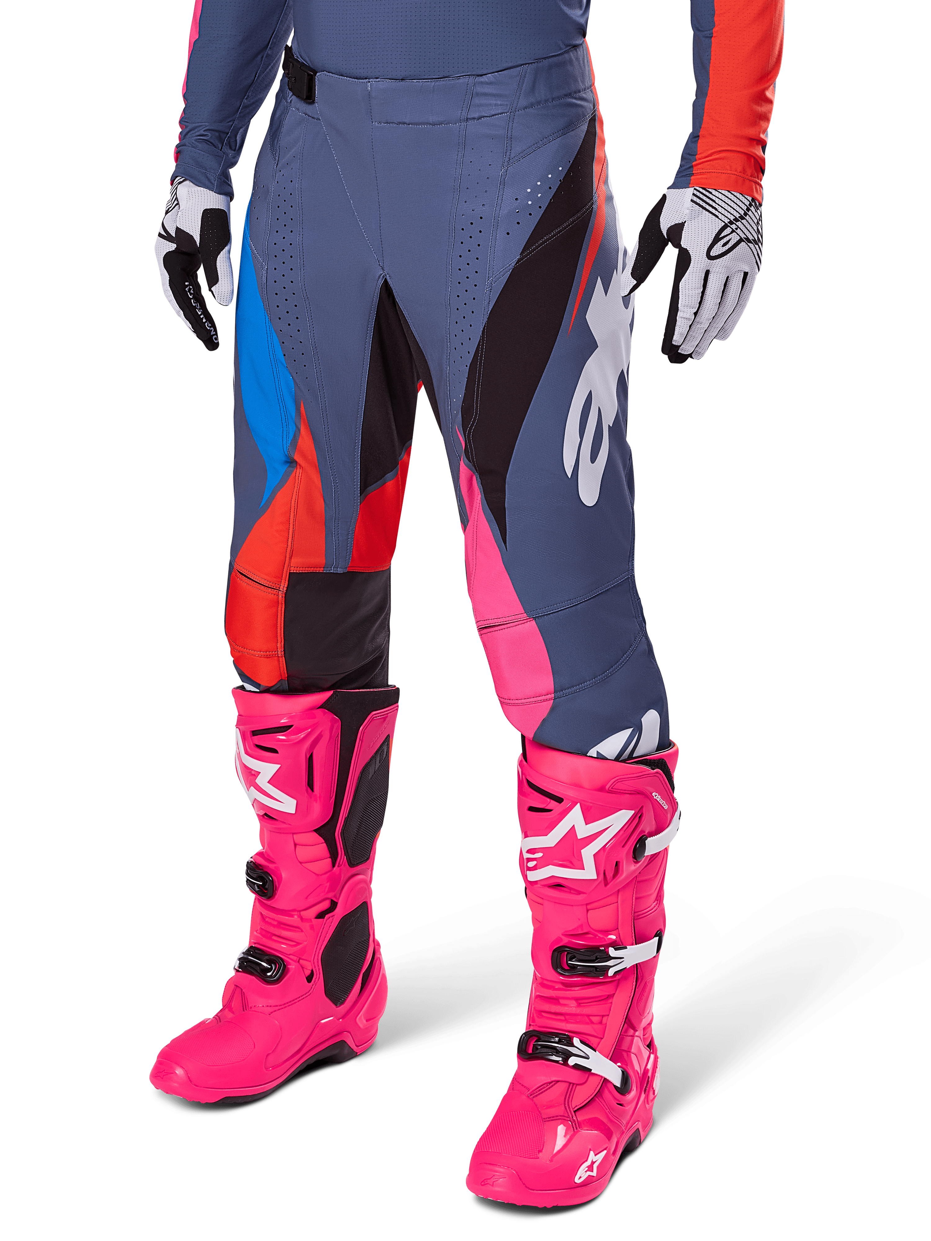 Alpinestars 2025 Techstar Dreem broek, motorcrossbroek, donkergrijs met blauwe, rode en roze panelen, witte graphics, gedragen met felroze laarzen en zwart-witte handschoenen, opvallend high-visibility ontwerp
