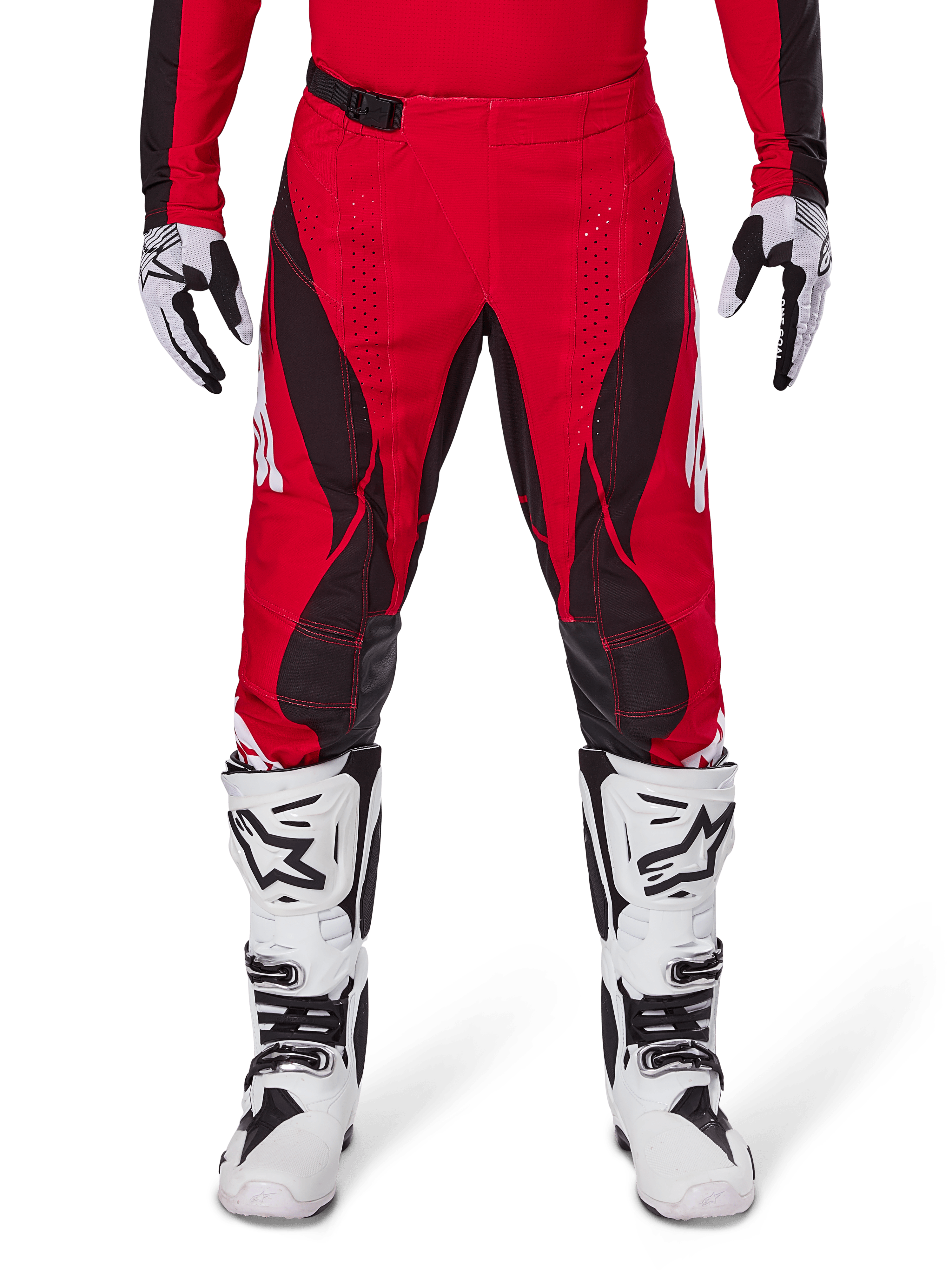 Alpinestars 2025 Techstar Dreem crossbroek, motorcross broek, helderrood en zwart, met hoekige patronen en lasergesneden ventilatiegaten, gedragen met witte motorcrosslaarzen en bijpassende handschoenen voor off-road racing