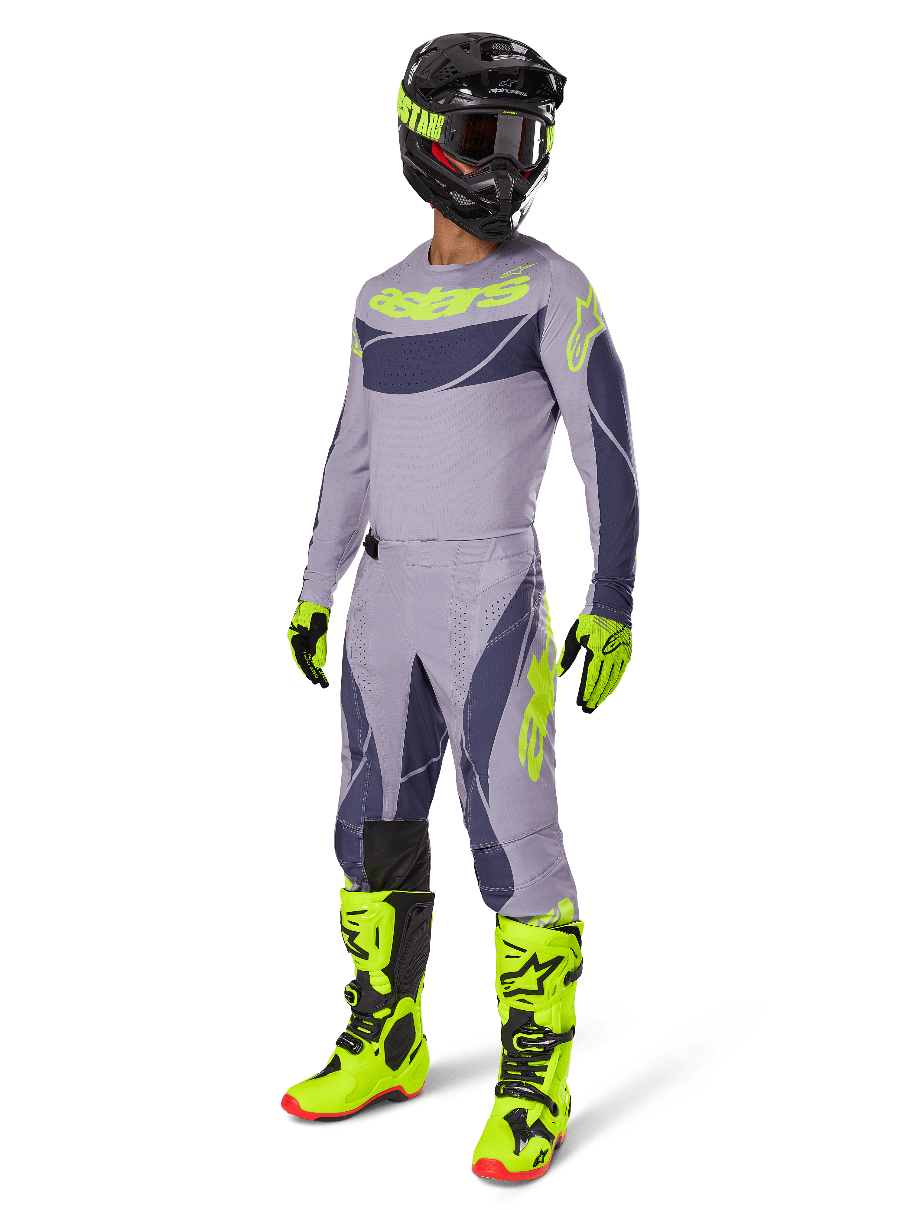Alpinestars 2025 Techstar Dreem crossbroek, motorcrossbroek, grijs en donkergrijs met neongroene accenten, gedragen met bijpassende jersey, fel neongroene laarzen en zwarte helm, volledige professionele motorcrossuitrusting