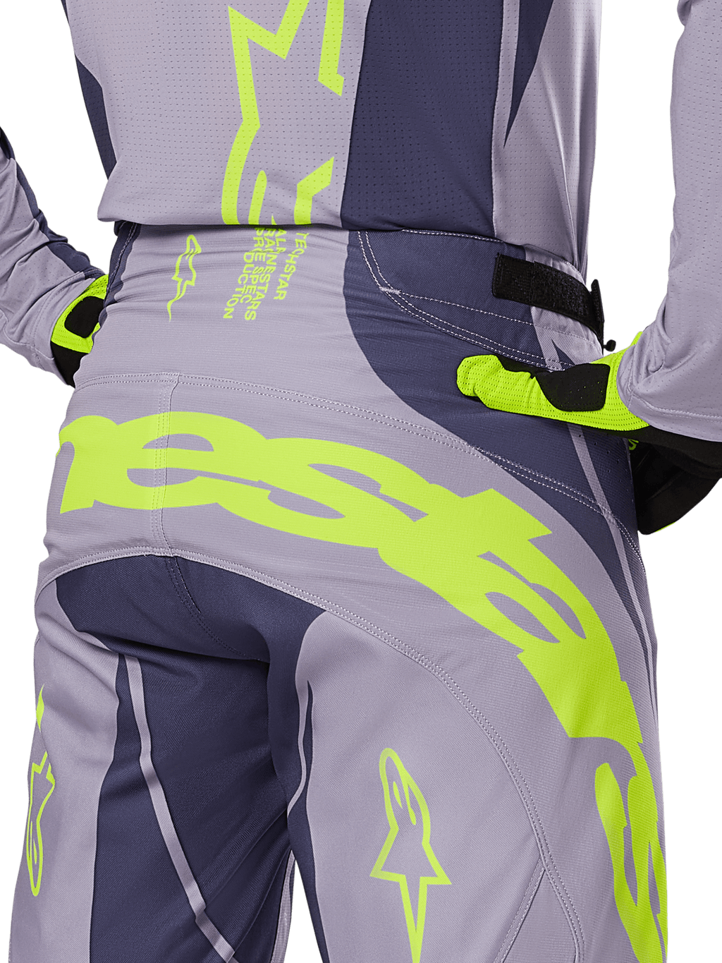 Alpinestars 2025 Techstar Dreem crossbroek, motorcross broek, grijs en donkergrijs met fluorescerende gele accenten, achteraanzicht met opvallende Alpinestars-branding op het achterpand, gedragen met bijpassende jersey en handschoenen, ontworpen voor off-road racing.