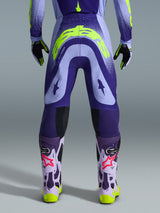 Alpinestars 2026 Supertech Scenz broek, motorcrossbroek, paars en fluogeel, achteraanzicht met groot geel logo op het zitvlak, gedragen met bijpassende jersey, handschoenen en beschermende laarzen, atletische pasvorm voor professionele motorcrossraces