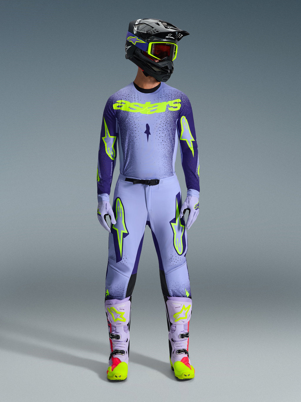 Alpinestars 2026 Supertech Scenz Pants, Motocross Pants, Purple Yellow Fluo, worn as a complete racing gear set with matching lavender jersey, gloves, and boots, featuring bold yellow fluo logos, athletic fit design for professional off-road racing.