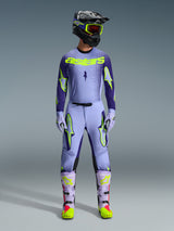 Alpinestars 2026 Supertech Scenz broek, motorcross broek, Purple Yellow Fluo, gedragen als een complete race-uitrusting met bijpassende lavendel jersey, handschoenen en laarzen, voorzien van opvallende geel fluo logo's, atletische pasvorm voor professionele off-road racing.