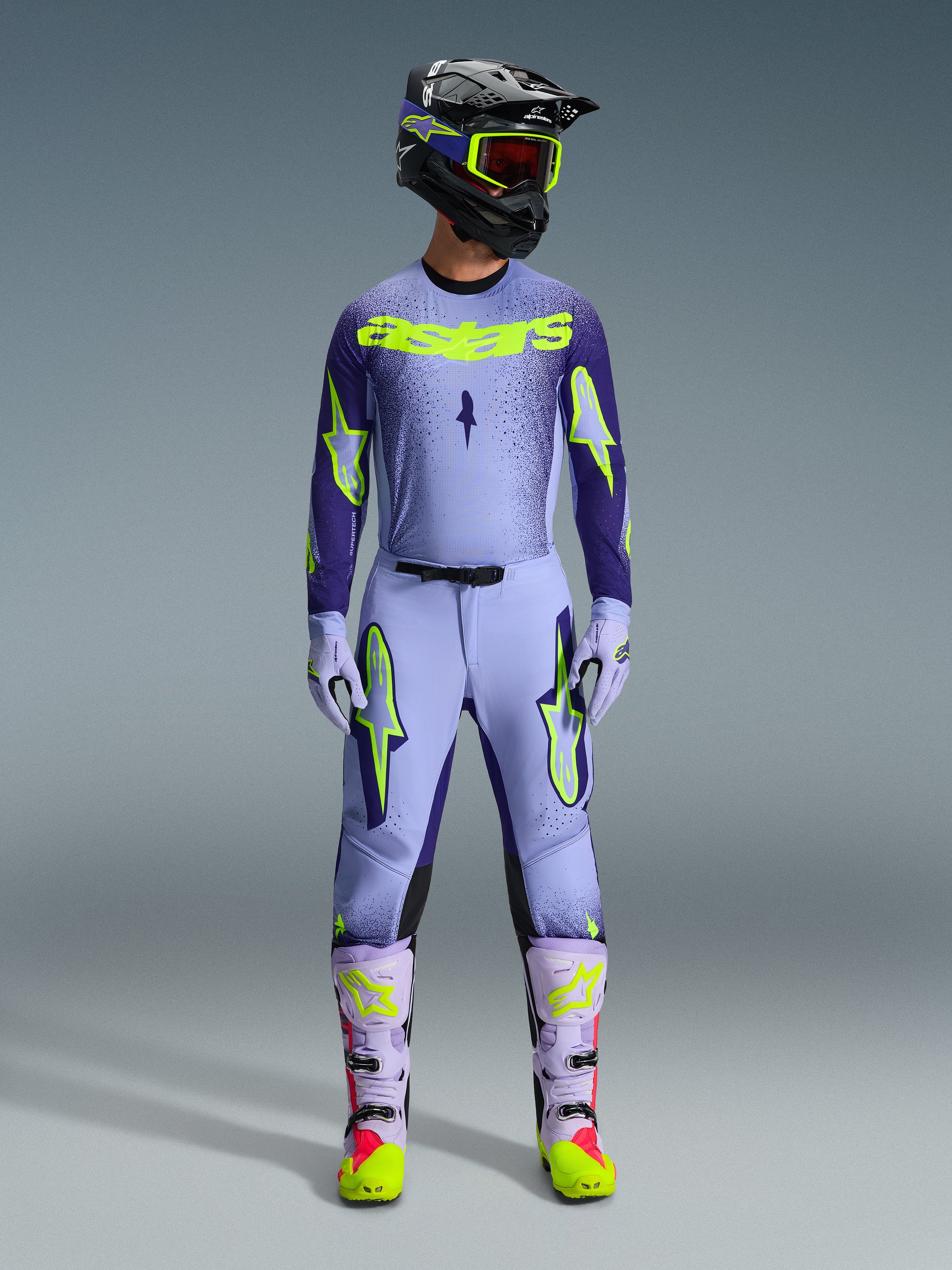 Alpinestars 2026 Supertech Scenz Gear Set, Motocross Racing Outfit, Light Purple and Neon Yellow-Green, full protective gear including black helmet with purple accents, jersey with bold neon yellow branding, matching pants with star graphics, and coordinated boots with pink highlights.