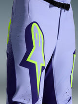 Alpinestars 2026 Supertech Scenz crossbroek, motorcross broek, paars met fluogeel, close-up met groot geel logo op de dij, lasergesneden perforaties voor ventilatie en magnetische gesp bij de taille, sportieve off-road uitrusting