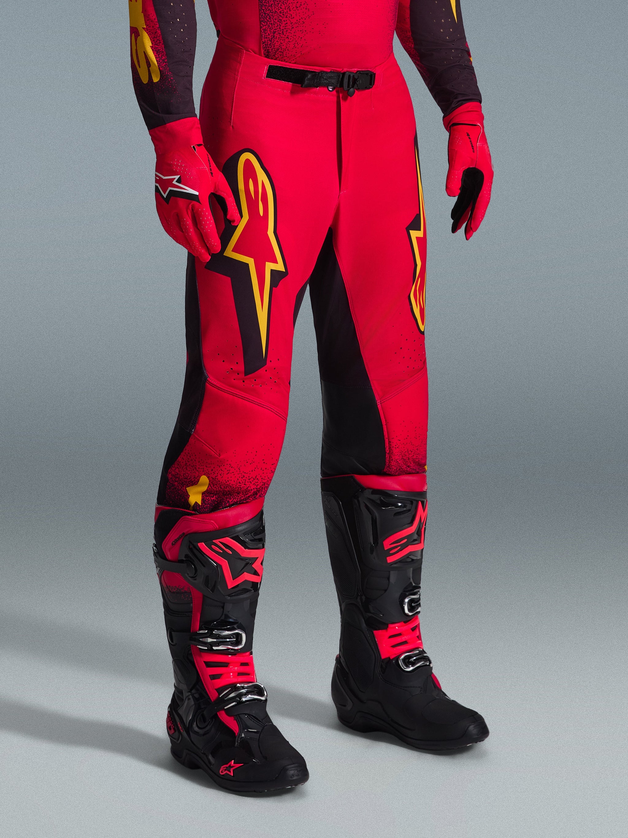 Alpinestars 2026 Supertech Scenz broek, motorcrossbroek, rood, zwart en geel, met gele Alpinestars-logo's en zwarte panelen, gedragen met bijpassende rode jersey, rode handschoenen en zwarte motorcrosslaarzen