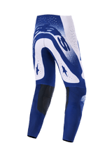 Alpinestars 2026 Supertech Scenz broek, motorcrossbroek, lichtgrijs en donkerblauw, achteraanzicht met opvallende witte en blauwe graphics en grote Alpinestars-logo's, atletische pasvorm met donkere kniepanelen aan de binnenzijde