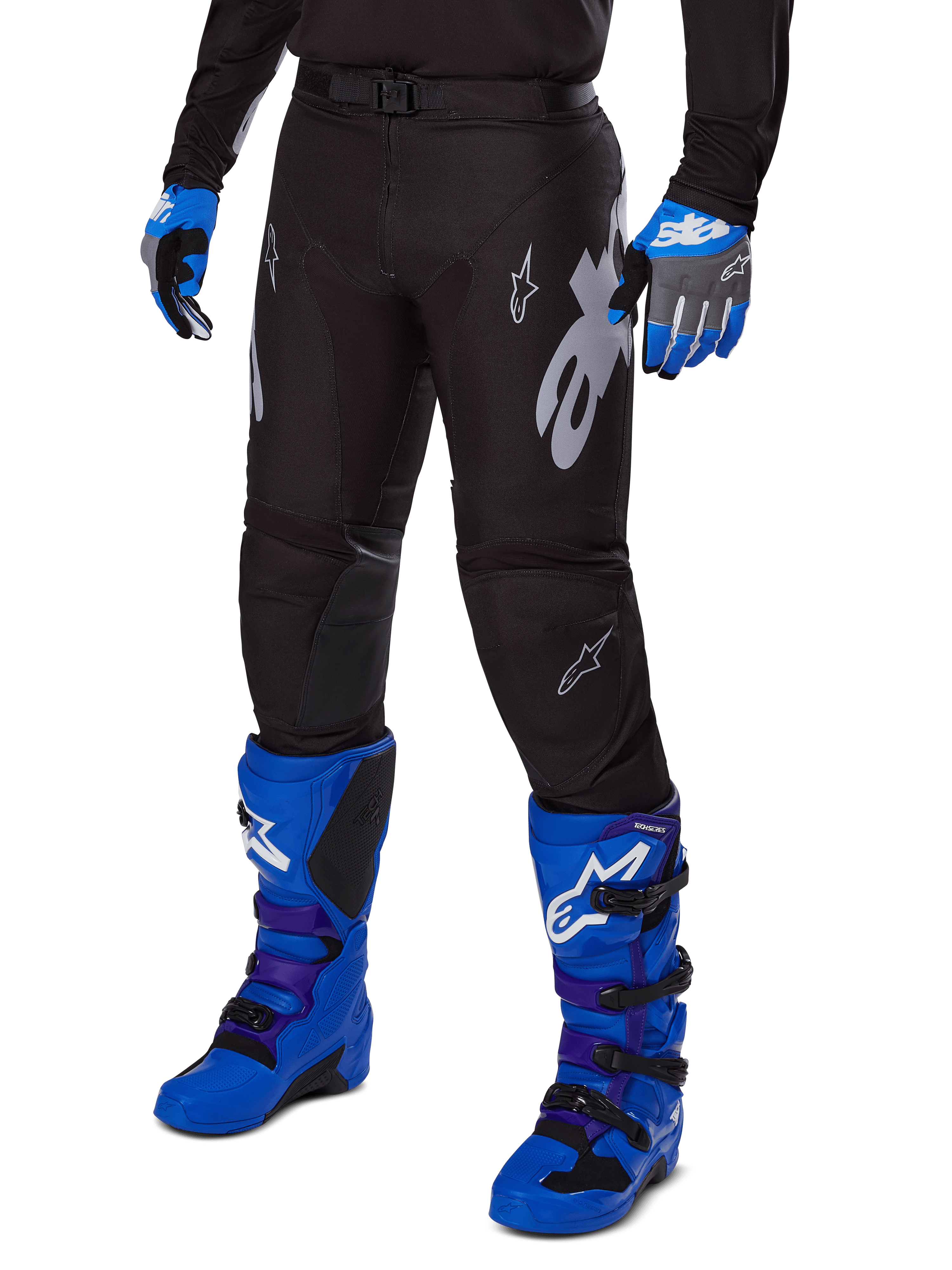 Alpinestars 2025 Racer Graphite Pants, zwarte motorcrossbroek met witte en grijze graphics, gedragen met felblauwe motorcrosslaarzen en bijpassende blauwe handschoenen, duurzaam materiaal voor off-road rijden