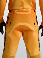 Alpinestars Racer Amber broek, heren motorcrossbroek, oranje en donkerblauw, met versterkt zitvlak en Astars-logo.