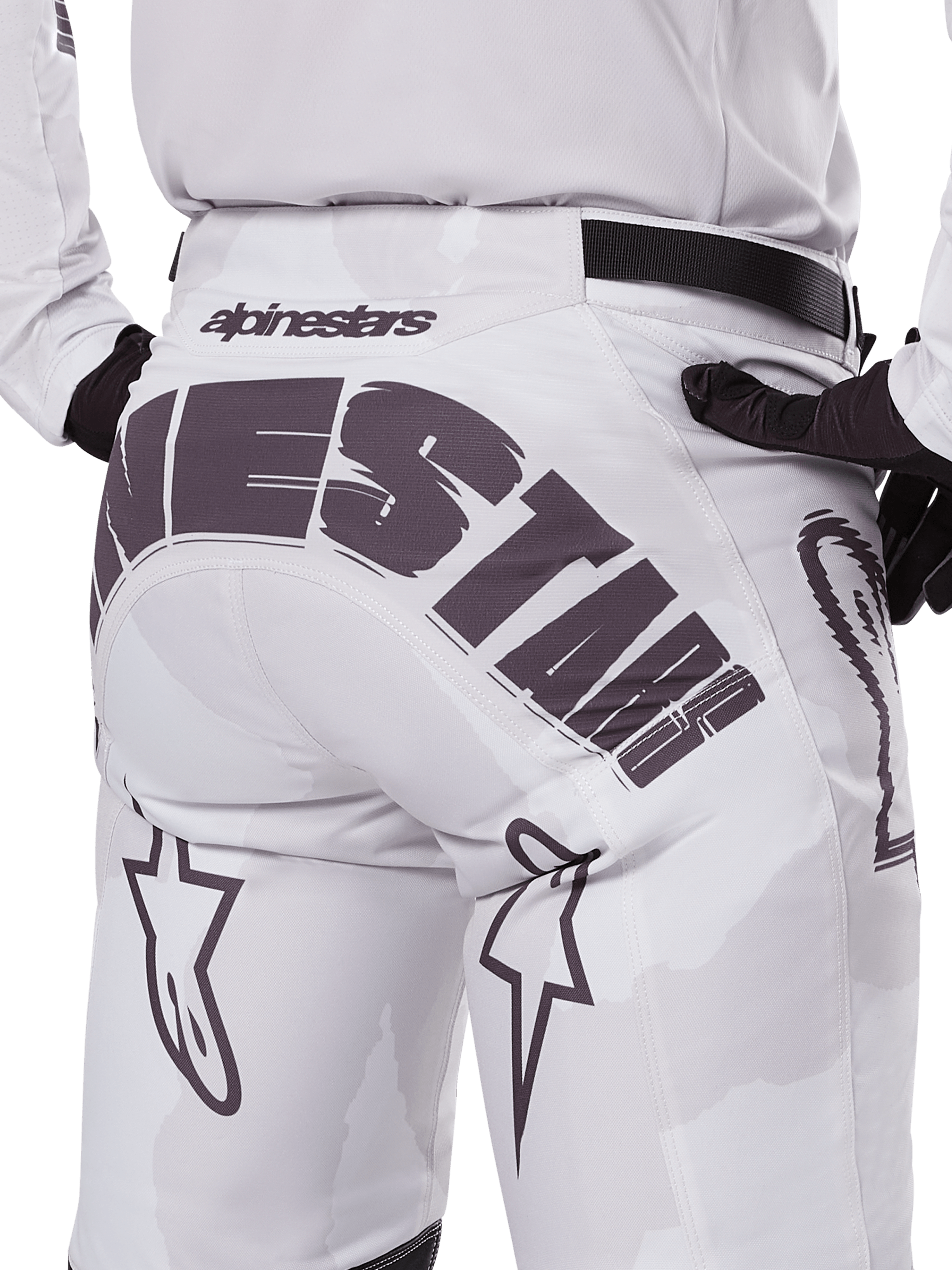 Alpinestars 2025 Racer Hollow broek, motorcrossbroek, licht camo bruin, close-up achteraanzicht met grote Alpinestars-branding op het zitvlak, ster-logo's op de benen en een zwarte verstelbare tailleband, ontworpen voor off-road racing