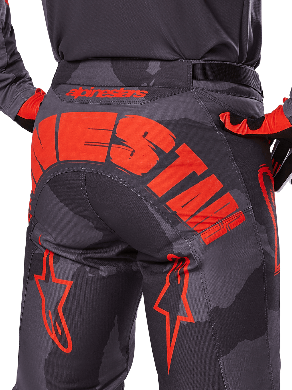 Alpinestars 2025 Racer Hollow broek, motorcrossbroek, Grijs Camo Fluo Oranje, achteraanzicht met groot oranje Alpinestars-logo op het zitvlak, camouflagepatroon met felle oranje accenten, duurzame off-road race-uitrusting