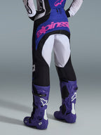 Alpinestars 2026 Techstar Knif Pants, Motocross Pants, Black Light Gray and Purple, rear view featuring pink branding on the seat, worn with matching jersey and purple motocross boots, professional off-road racing outfit