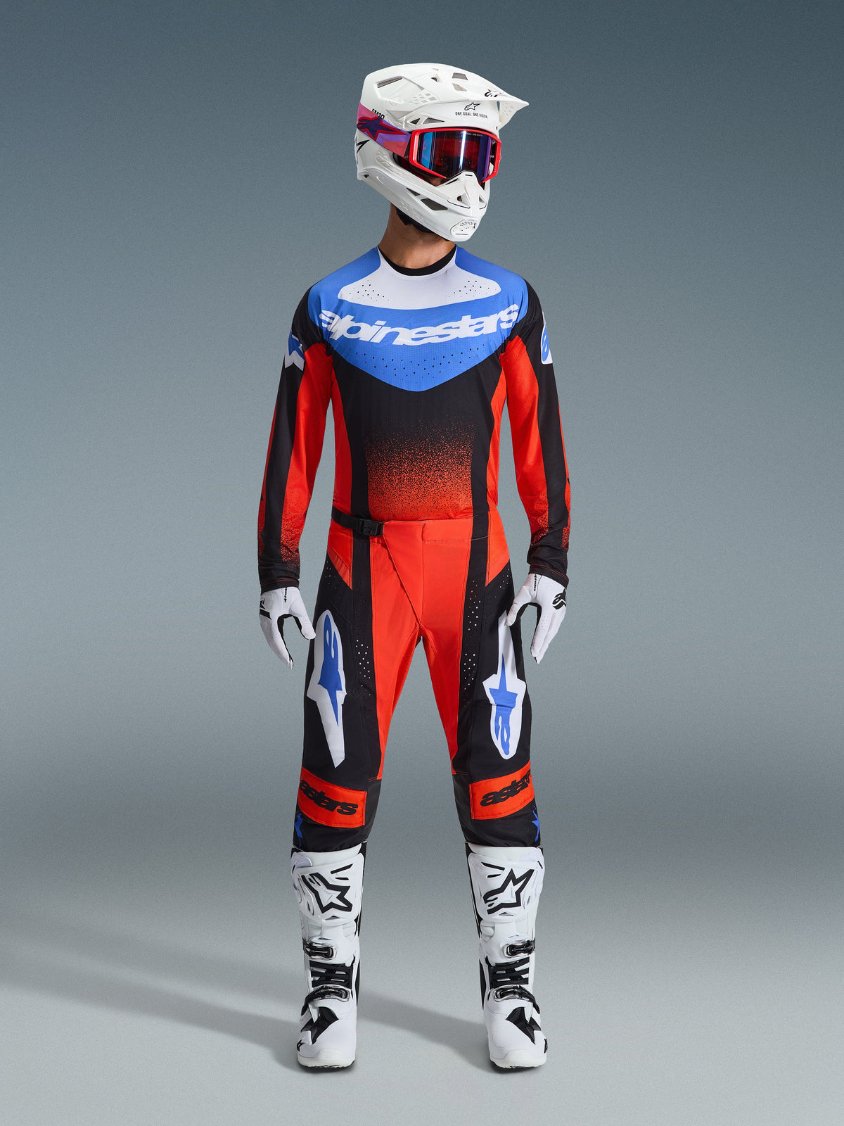 Alpinestars 2026 Techstar Knif Gear Set, motorcross race-uitrusting, rood en zwart met blauwe accenten, complete MX-outfit inclusief jersey, broek, witte helm met roze en blauwe graphics, witte handschoenen en witte laarzen, professionele off-road race-uitrusting