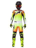 Alpinestars 2025 Fluid Wurx broek, motorcross broek, geel en zwart met oranje en wit kleurverloop, gedragen met bijpassende jersey, felgele laarzen en zwarte helm met rode bril, volledige motorcross race-uitrusting
