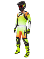 Alpinestars 2025 Fluid Wurx broek, motorcross broek in geel en zwart met een levendig geel-naar-wit kleurverloop en oranje accenten, gedragen door een motorcrosser als onderdeel van een complete outfit met bijpassende jersey, zwarte helm en neongele laarzen.