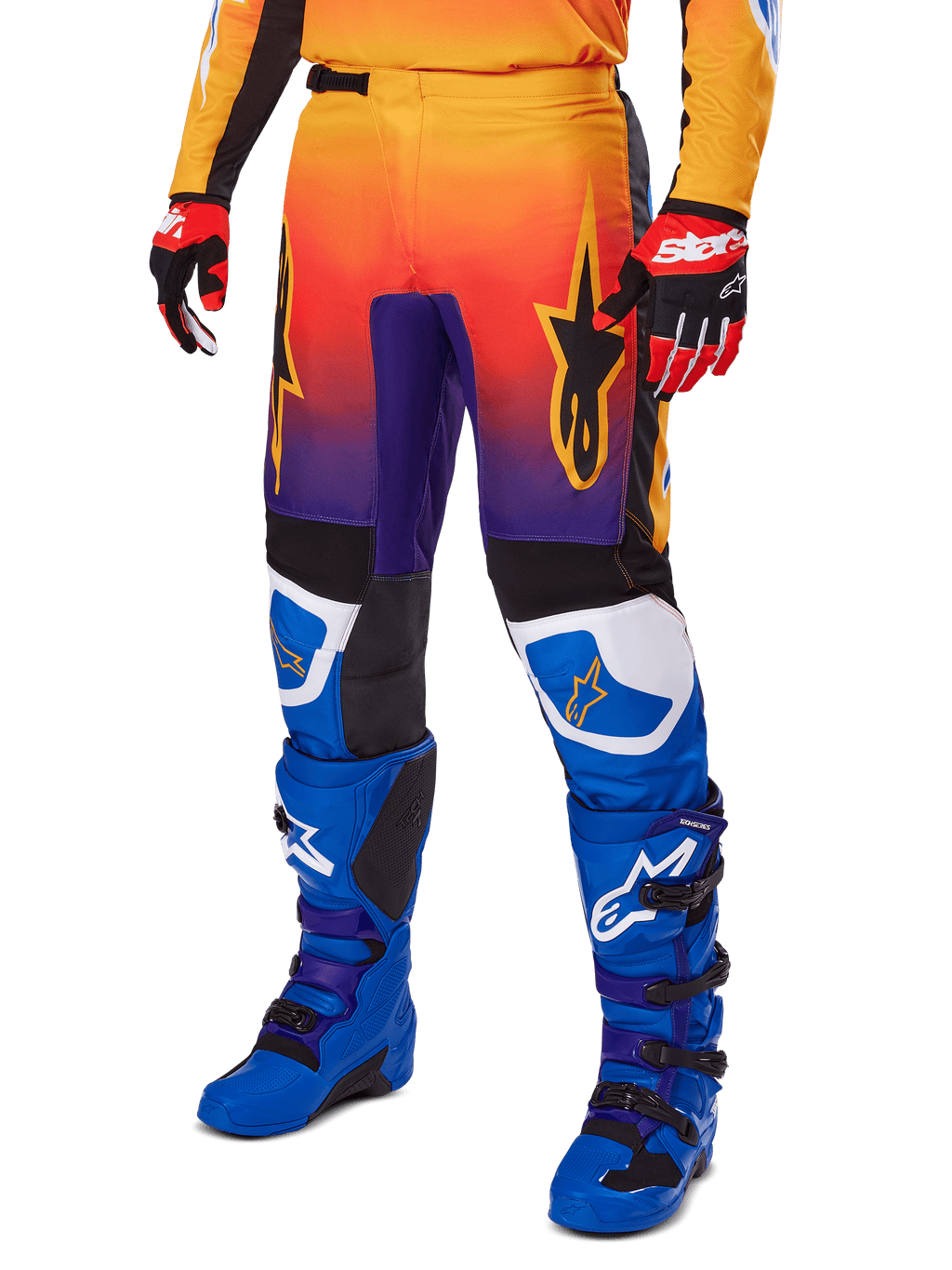 Alpinestars 2025 Fluid Wurx broek, motorcrossbroek, multicolor oranje, rood en paars kleurverloop met zwarte en blauwe panelen, gedragen met blauwe laarzen en rode handschoenen, voorzien van sterlogo-graphics en witte knie-accenten, duurzame prestatiegerichte uitrusting voor off-road racing