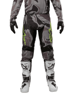 Alpinestars 2024 Racer Tactical crossbroek, motorcrossbroek, Cast Gray Camo Magnet, gedragen met bijpassende camouflage jersey, zwarte handschoenen en witte en zwarte laarzen, voorzien van limegroene sterlogo's op de dijen en zwarte stretchpanelen, vooraanzicht van off-road rijuitrusting