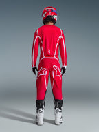 Alpinestars 2026 Fluid Apex Pants, Motocross Pants, Red and White, rear view worn with matching jersey, red helmet, and white and black boots, featuring large white Astar logos on the legs, coordinated outfit for off-road racing
