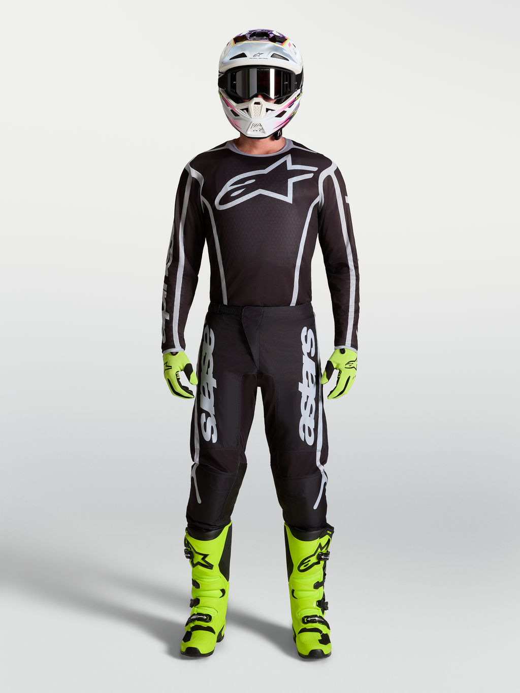 Alpinestars Fluid Apex V2 motocrossbroek, zwart en zilver, onderdeel van een herenset met neongele motorlaarzen en helm.