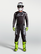 Alpinestars Fluid Apex V2 motocrossbroek, zwart en zilver, onderdeel van een herenset met neongele motorlaarzen en helm.