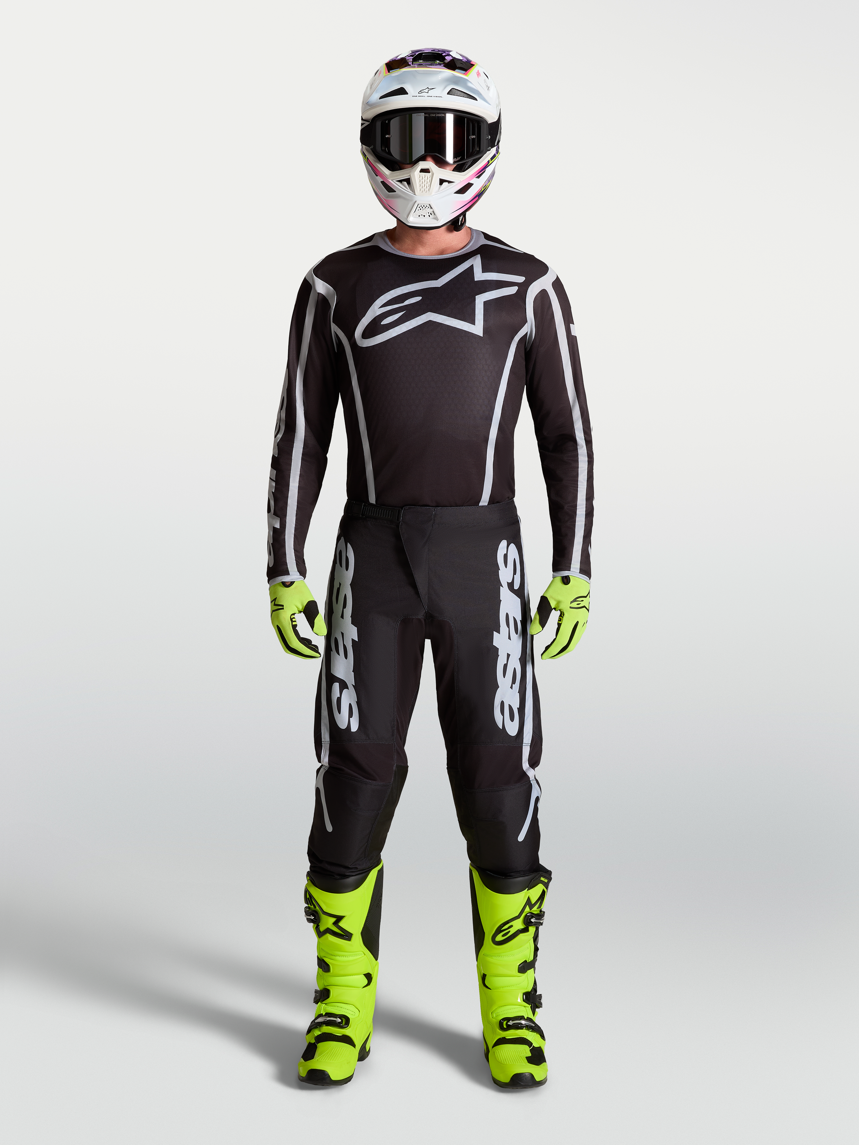 Alpinestars Fluid Apex V2 motocrossbroek, zwart en zilver, onderdeel van een herenset met neongele motorlaarzen en helm.