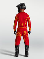 Alpinestars Fluid Apex V2 motocrossbroek in rood en goud, met verstevigd zitvlak en ergonomische sportpasvorm.
