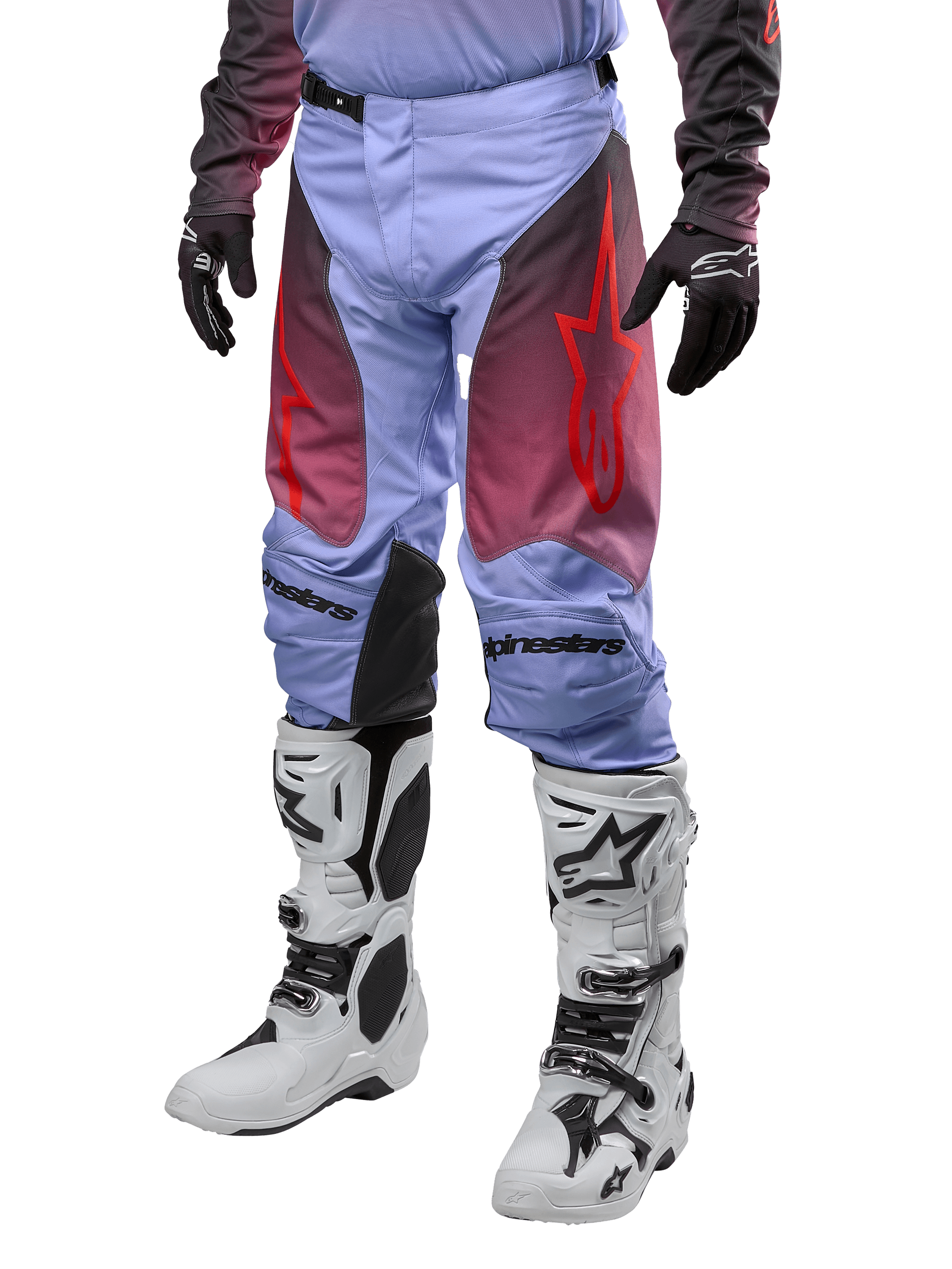 Alpinestars 2024 Racer Hoen broek, motorcross broek, Lavan paars en zwart met rode graphics, voorzien van rode sterlogo's op de bovenbenen en zwarte belettering op de knieën, gedragen met wit-zwarte laarzen en zwarte handschoenen