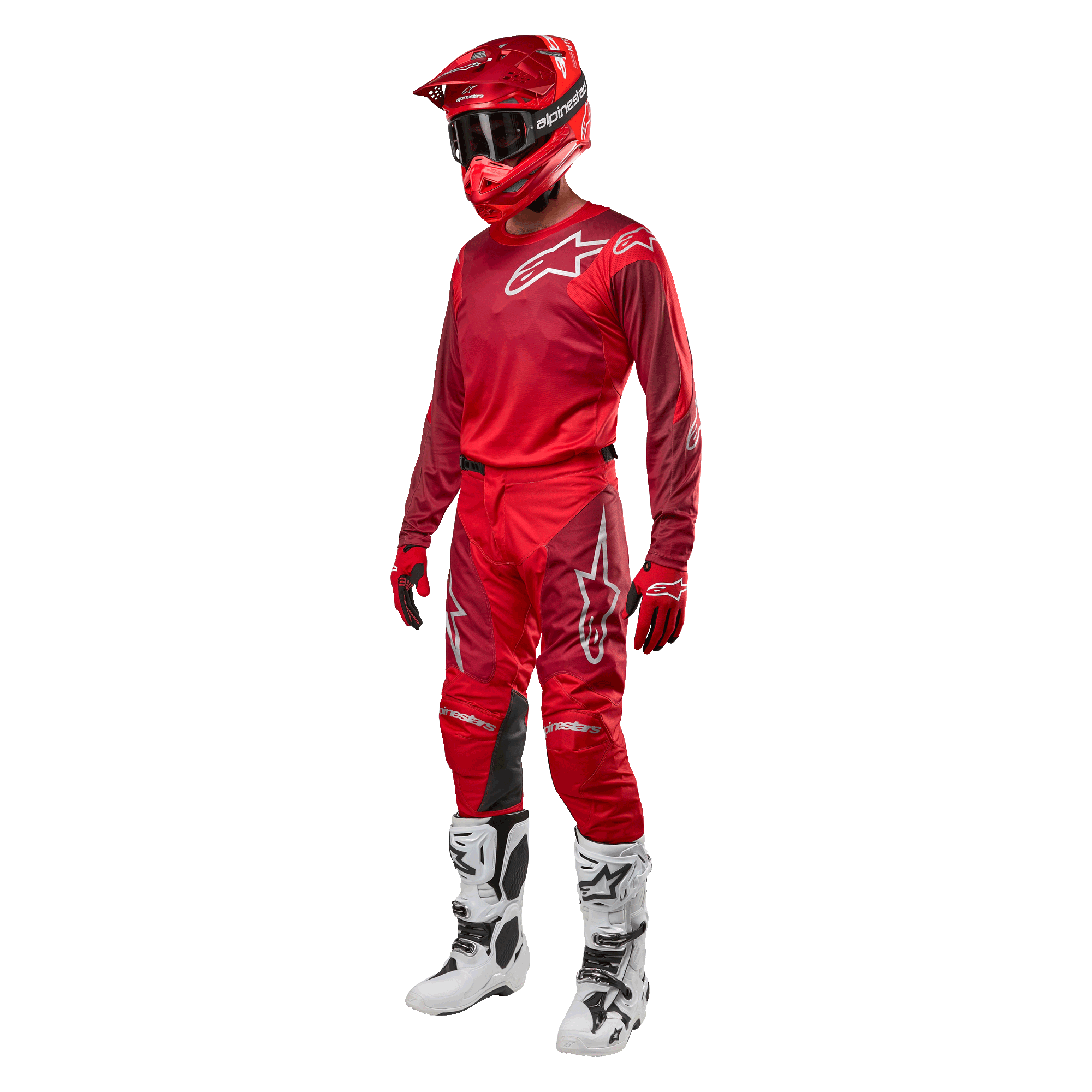 Motorcrosser in volledige race-uitrusting, Alpinestars 2024 Racer Hoen broek en jersey in Mars Red Burgundy, rode helm, rode handschoenen en witte en zwarte laarzen, gecoördineerde outfit voor off-road rijden