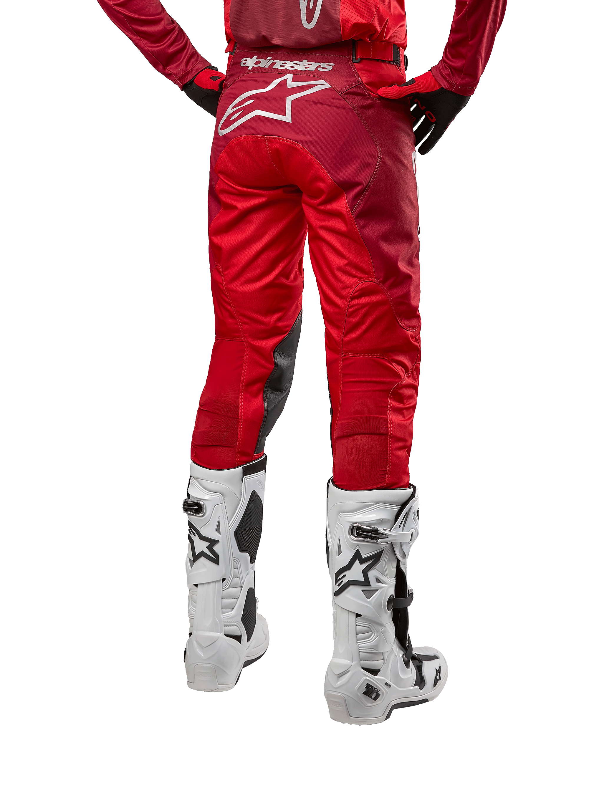 Alpinestars 2024 Racer Hoen broek, motorcrossbroek, Mars Red Burgundy, achteraanzicht met een groot wit Astar-logo op de achterzijde, zwarte kniepanelen aan de binnenzijde, gedragen met witte motorcrosslaarzen, hoogwaardige off-road uitrusting