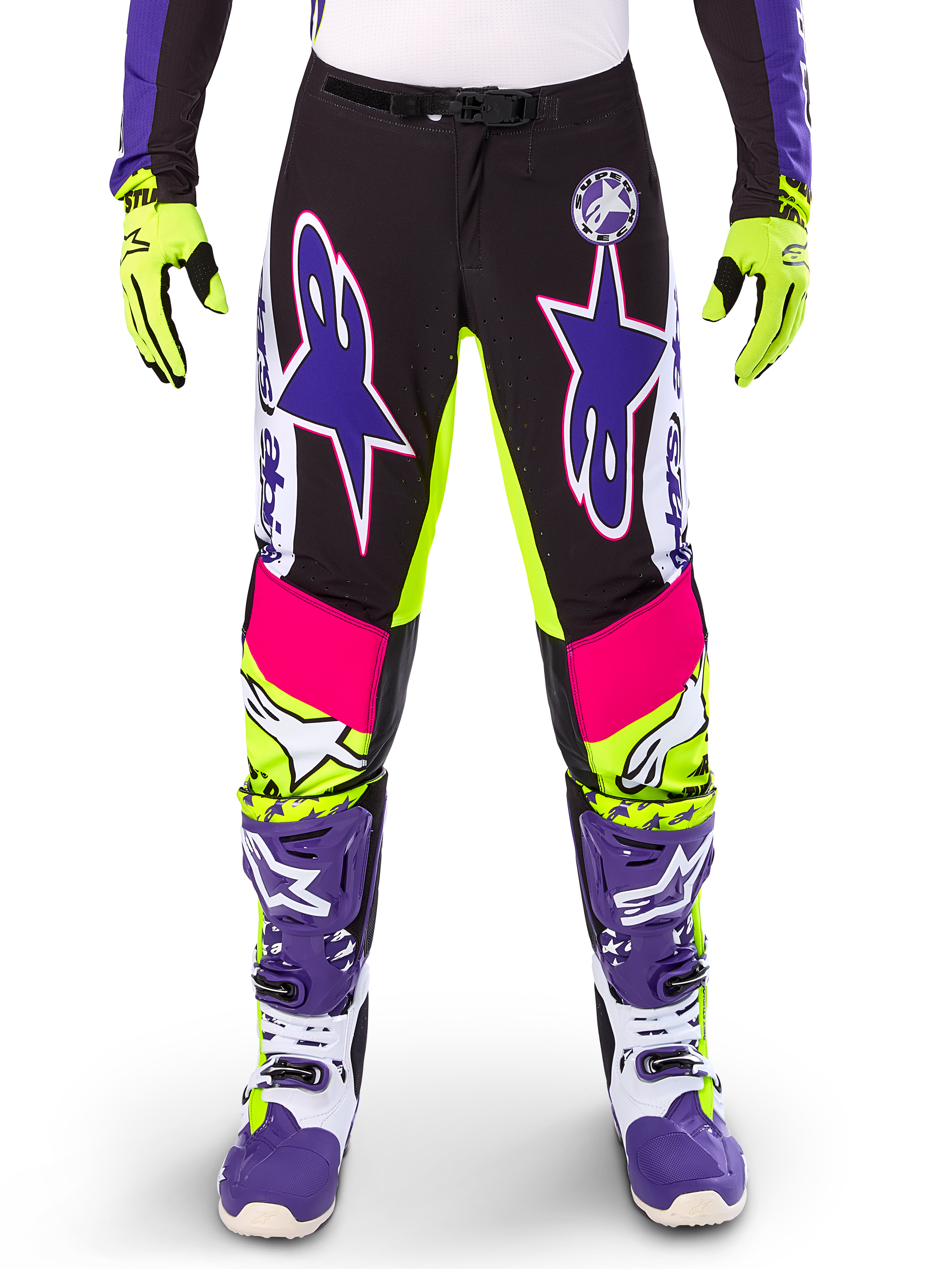 Alpinestars Limited Edition Supertech Dirt Studios motorbroek, motorcrossbroek, wit, paars en neongeel, voorzien van zwarte panelen met neongele en roze accenten, grote paarse sterlogo's, getoond met bijpassende neongele handschoenen en paarse racelaarzen, duurzame off-road racekleding