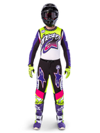Alpinestars motorcrossrijder in volledige race-uitrusting, Limited Edition Supertech Dirt Studios jersey en broek in wit, paars en fluorgeel, zwarte helm met bril, paarse en witte laarzen, gecoördineerde levendige outfit voor off-road motorcross