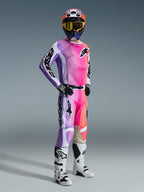 Alpinestars 2026 Racer Air Portl Jersey, motorcrossrijder met bijpassende broek, levendig roze, paars en oranje multicolor kleurverloop met witte accenten, gecoördineerde kleurrijke helm en gele bril, witte en zwarte laarzen, complete race-outfit voor off-road prestaties