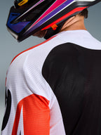 Alpinestars 2026 Racer Air Portl Jersey, motocross shirt, multicolor met witte, zwarte en rode panelen, close-up van de geperforeerde mesh-constructie op de schouder en rug voor ventilatie, gedragen met een kleurrijke motocrosshelm