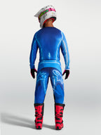 Alpinestars Fluid Kepler Broek, heren motorcrossbroek in UCLA blauw, achteraanzicht met ergonomische pasvorm en duurzame polystof, gedragen met rode laarzen voor off-road racing.