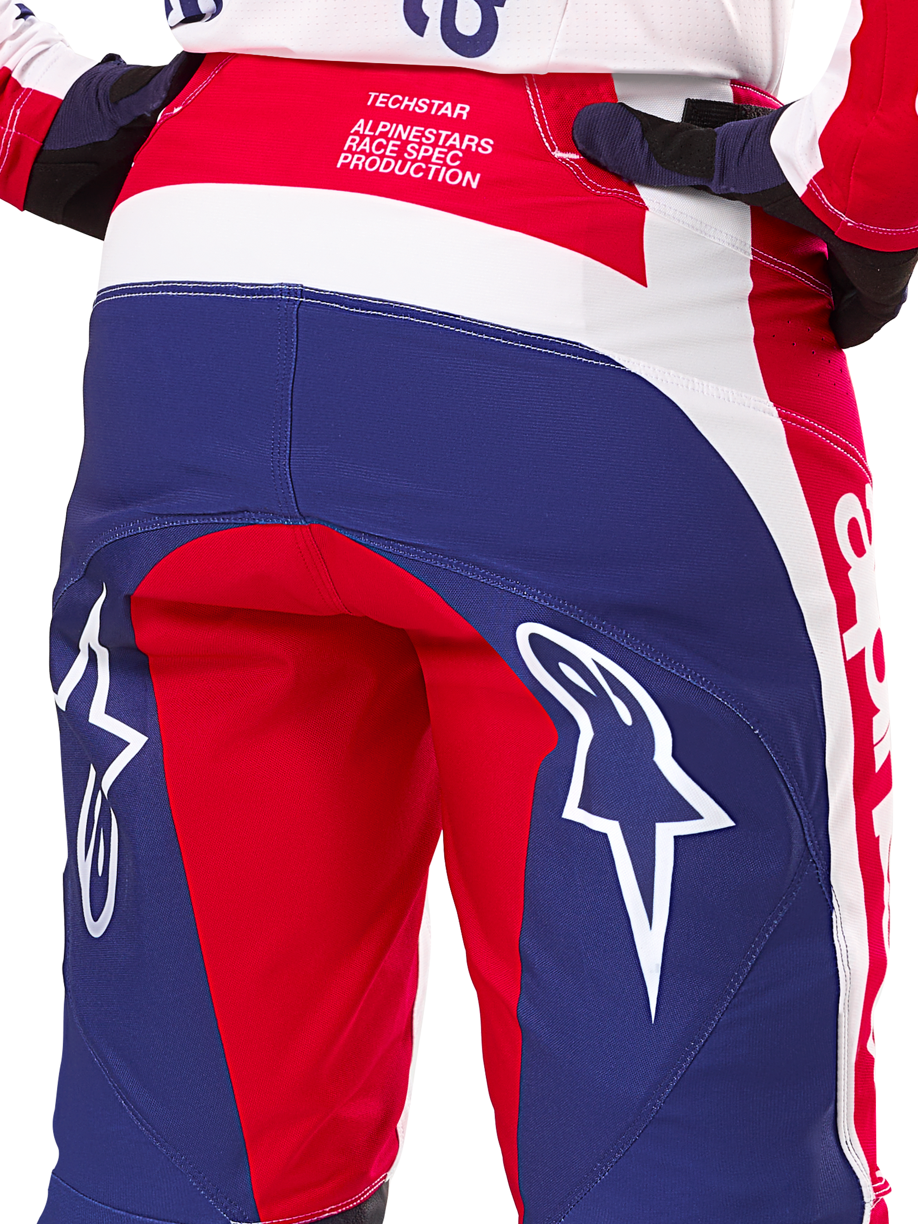 Alpinestars Limited Edition Techstar Fortitude broek, motorcrossbroek, rood, wit en blauw, achteraanzicht met grote witte sterlogo's op het zitvlak en Techstar Race Spec-branding, duurzaam hoogwaardig textiel voor off-road racen
