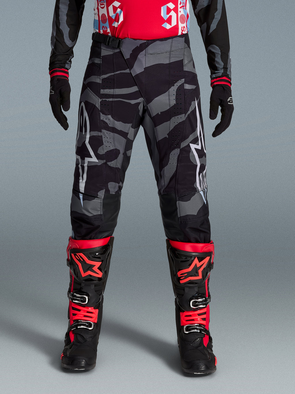 Alpinestars Limited Edition Techstar Beast Coast Pants, pirate black and orange motocross gear with a camo pattern.