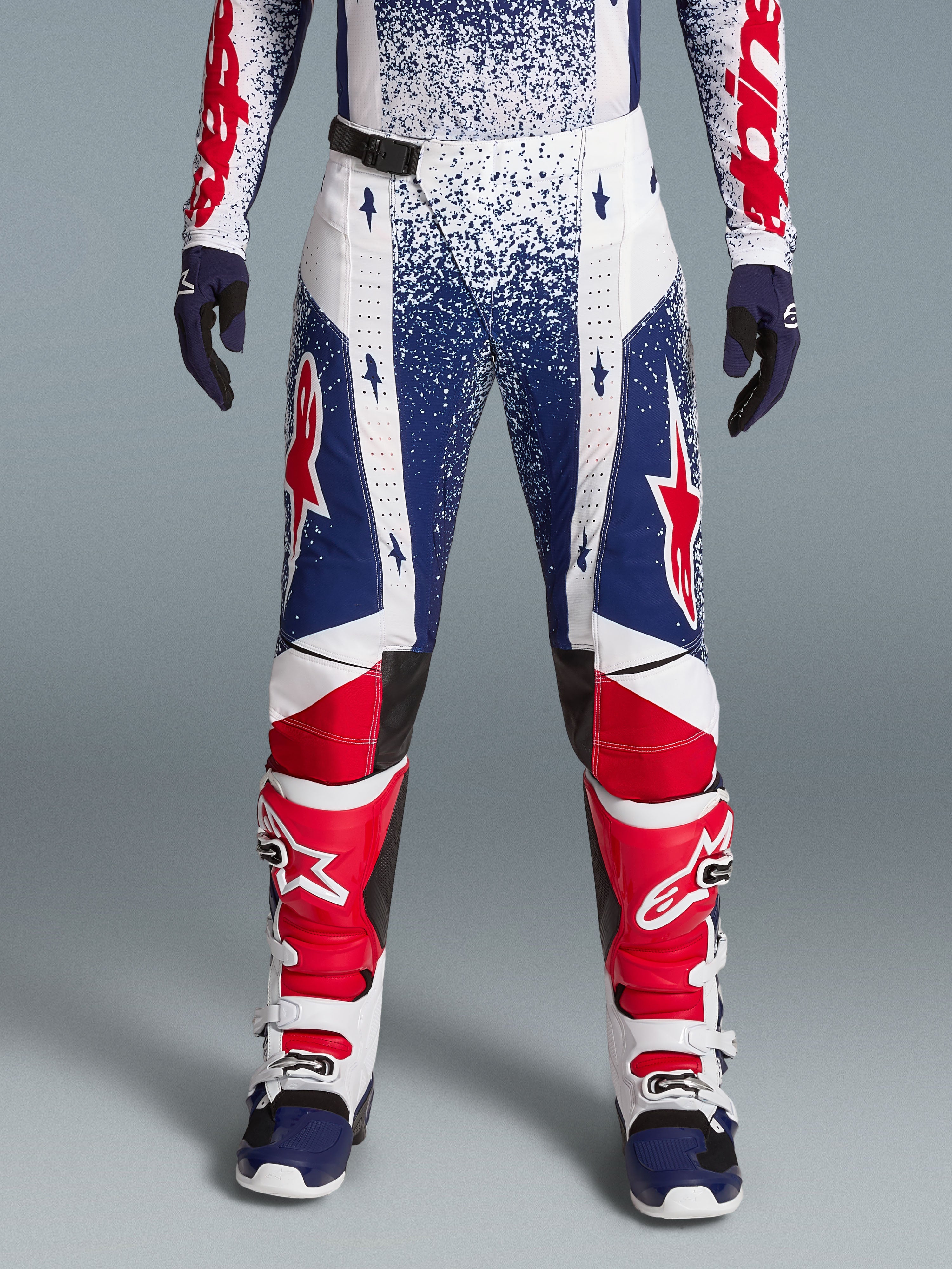 Alpinestars Techstar Unity limited edition heren-motorcrossbroek in rood, wit en blauw met sterrenpatroon.