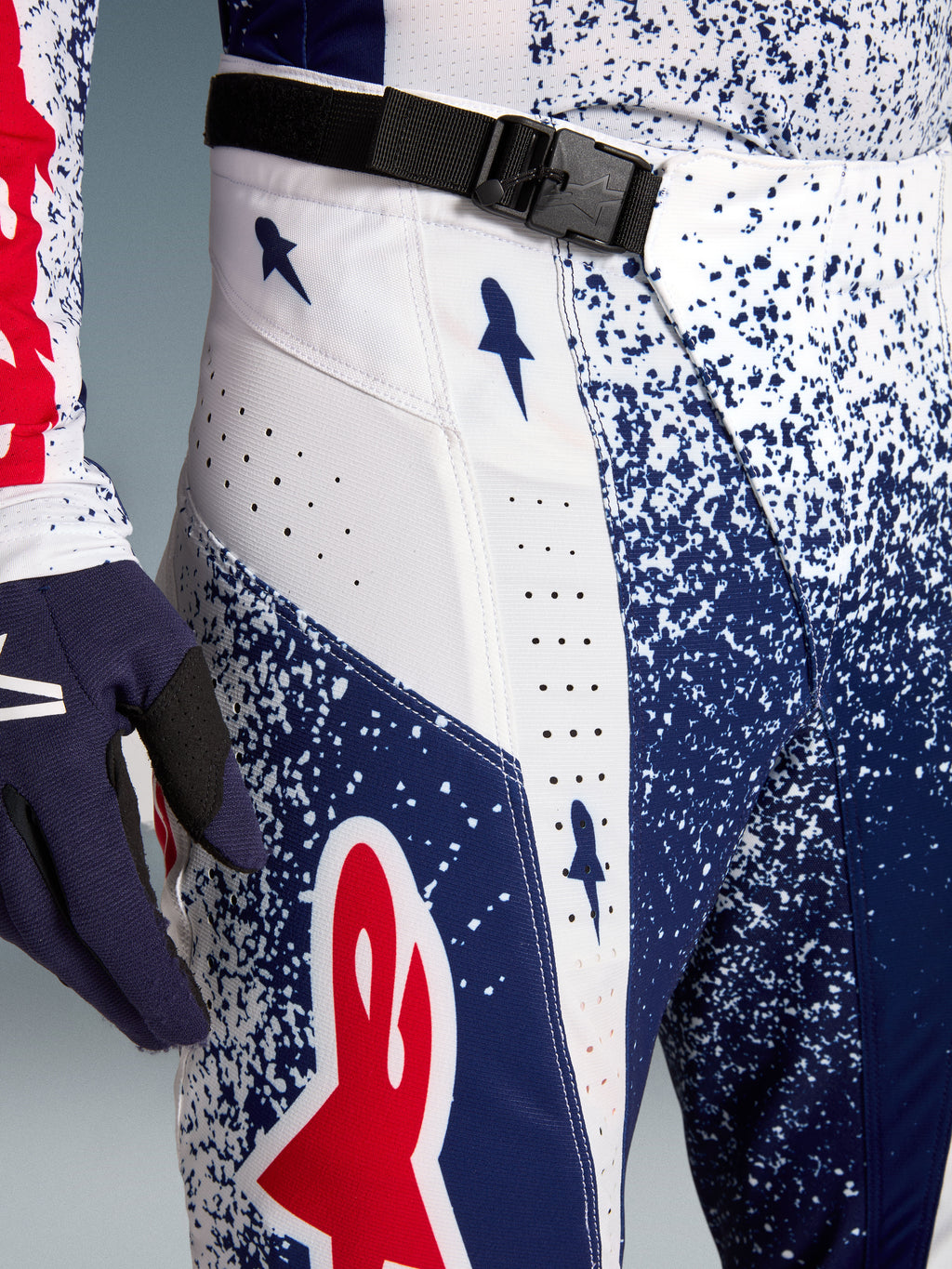 Alpinestars Techstar Unity motorcrossbroek, rood, wit en blauw met SX2 magnetische gesp en laserperforaties.