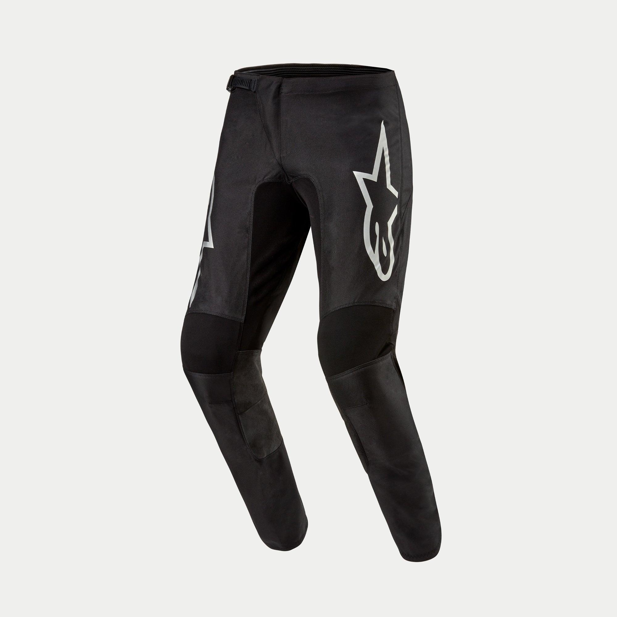 Alpinestars 2024 Fluid Graphite broek, motorcross broek, zwart en zilver, met een groot zilveren Astar-logo op de dij, zwarte verstevigde kniepanelen en een ergonomisch voorgevormd ontwerp voor off-road rijden