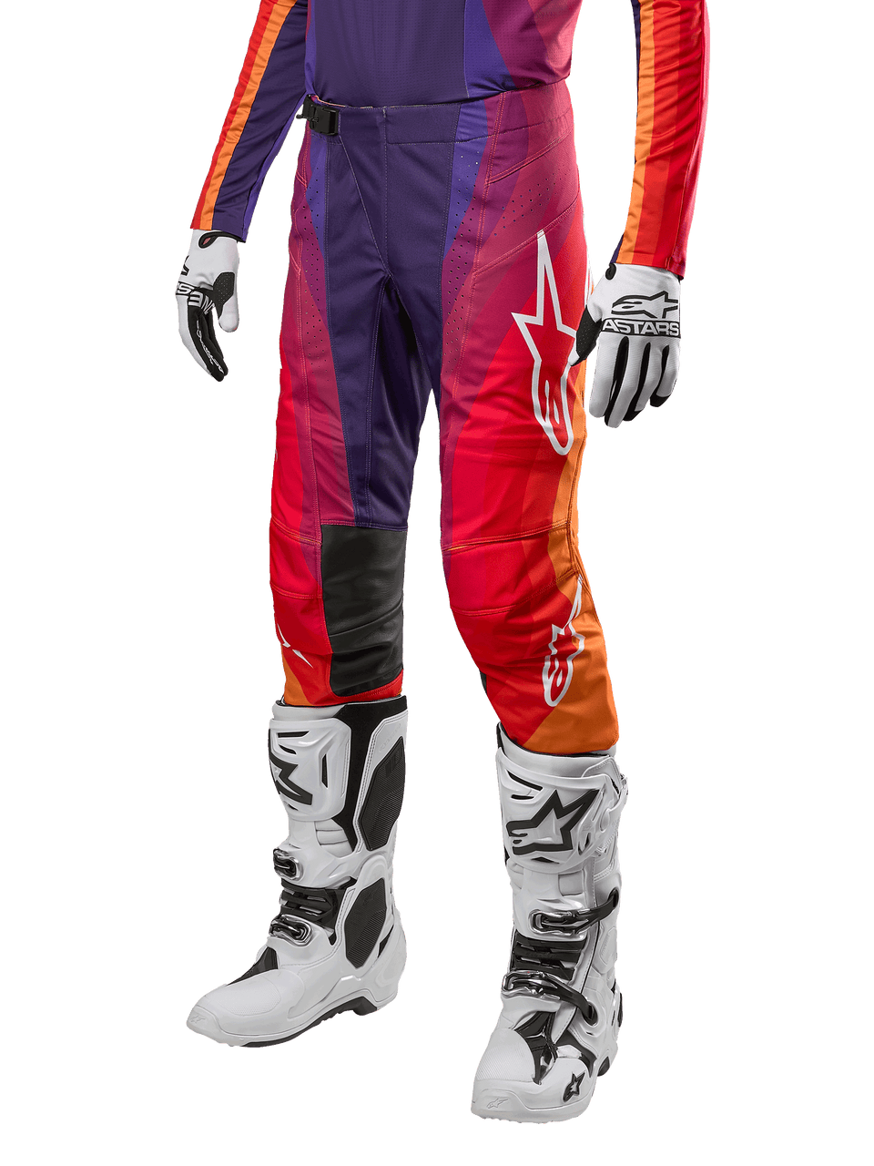 Alpinestars 2024 Techstar Pneuma crossbroek, motorcross broek, paars met oranje en blauw kleurverloop, witte logo's, persoon draagt de broek in combinatie met witte motorcrosslaarzen en handschoenen, sportieve off-road uitrusting