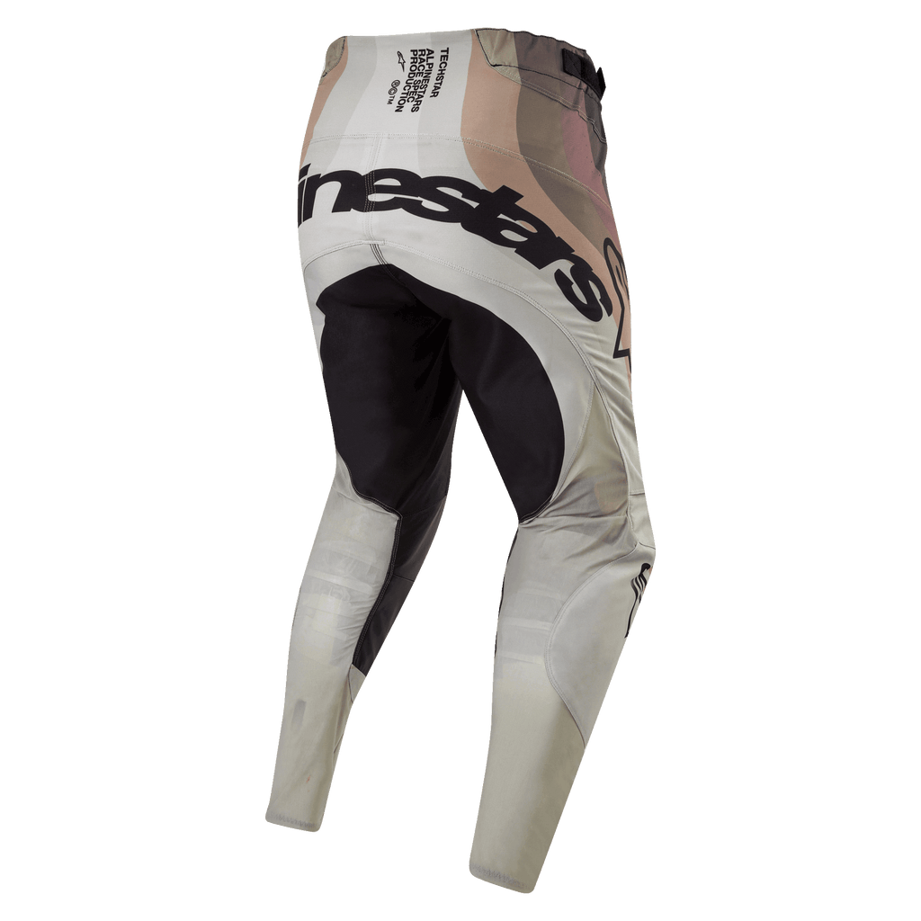 Alpinestars 2024 Techstar Pneuma broek, motorcrossbroek, Dark Sand en Iron Dust grijs, achteraanzicht met zwart verstevigd zitvlak en opvallende Alpinestars-branding over de achterzijde, technische race-spec tekst op de tailleband, aards camouflage-achtig ontwerp, duurzame textielconstructie voor off-road racen