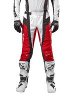 Alpinestars 2024 Techstar Ocuri broek, motorcrossbroek, Mars Red White Black (rood, wit en zwart), vooraanzicht gedragen met bijpassende witte jersey, zwarte handschoenen en witte laarzen, voorzien van ademende geperforeerde panelen en een race-geïnspireerde pasvorm voor off-road prestaties