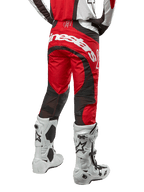 Alpinestars 2024 Techstar Ocuri crossbroek, motorcross broek, Mars Red, wit en zwart, achteraanzicht met groot wit Alpinestars-logo op het zitvlak, zwarte mesh ventilatiepanelen, gedragen met wit-zwarte motorcrosslaarzen, atletische race-fit voor off-road rijden