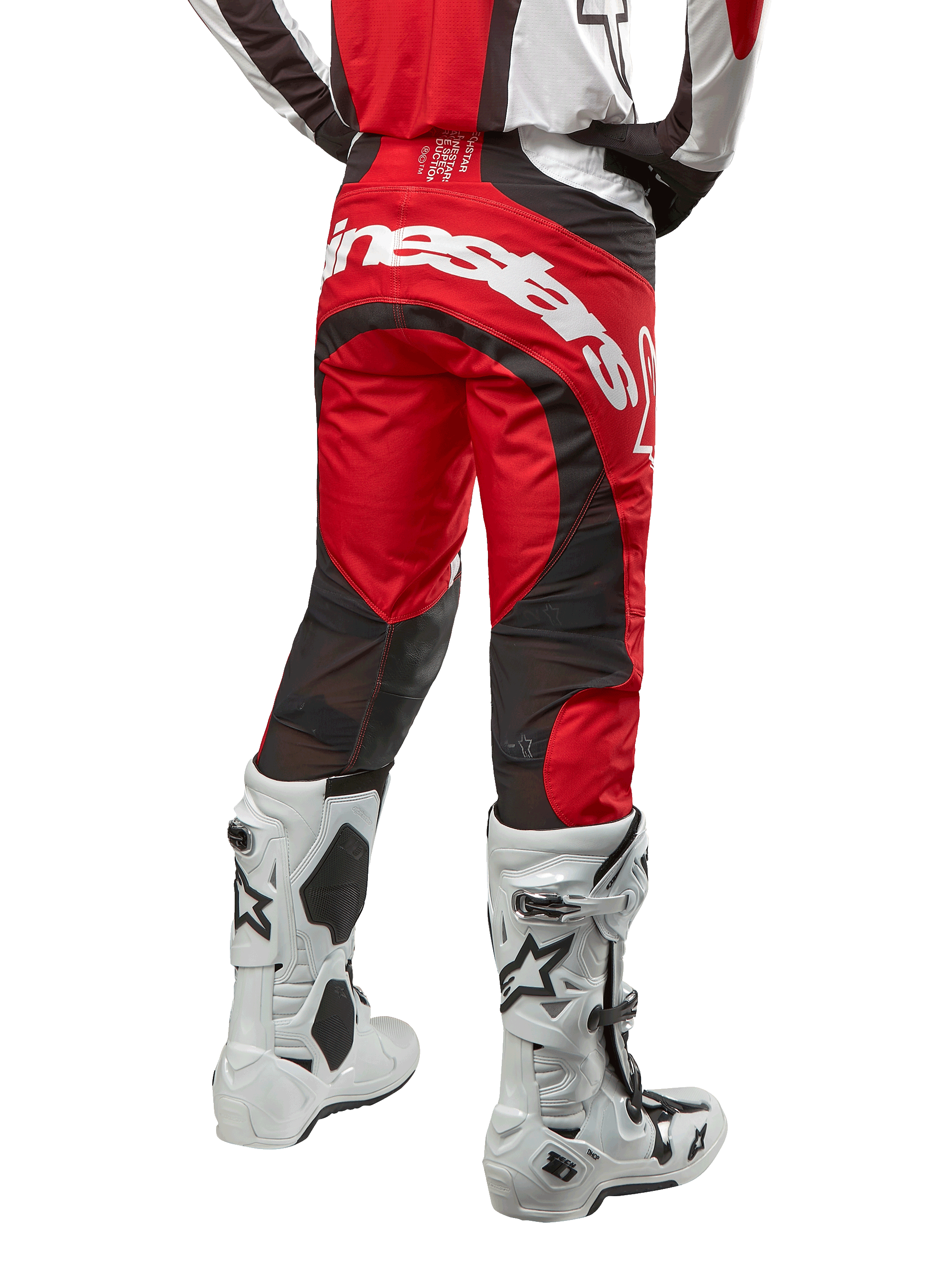 Alpinestars 2024 Techstar Ocuri crossbroek, motorcross broek, Mars Red, wit en zwart, achteraanzicht met groot wit Alpinestars-logo op het zitvlak, zwarte mesh ventilatiepanelen, gedragen met wit-zwarte motorcrosslaarzen, atletische race-fit voor off-road rijden