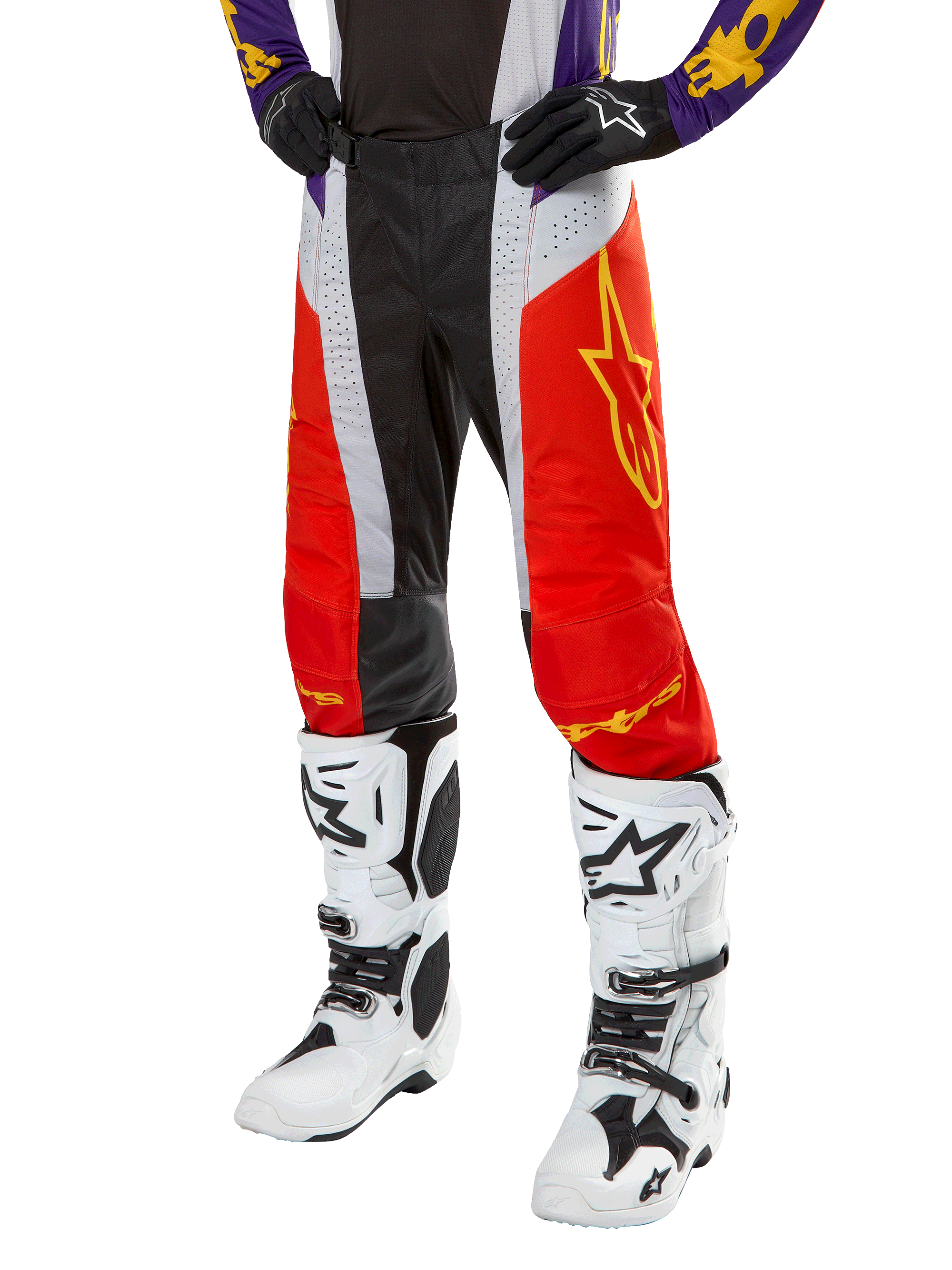 Alpinestars 2024 Techstar Ocuri crossbroek, motorcross racingbroek, feloranje, zwart en wit met geel sterrendesign, gedragen met paarse jersey en witte laarzen, duurzame performance kleding voor off-road competitie