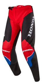 Alpinestars Honda Racer Iconic Pants, Motocross Pants, Bright Red Black and White with Blue accents, featuring a large white HONDA logo on the thigh, Alpinestars branding on the knees, ergonomic pre-curved leg construction, and adjustable ratchet waist closure.