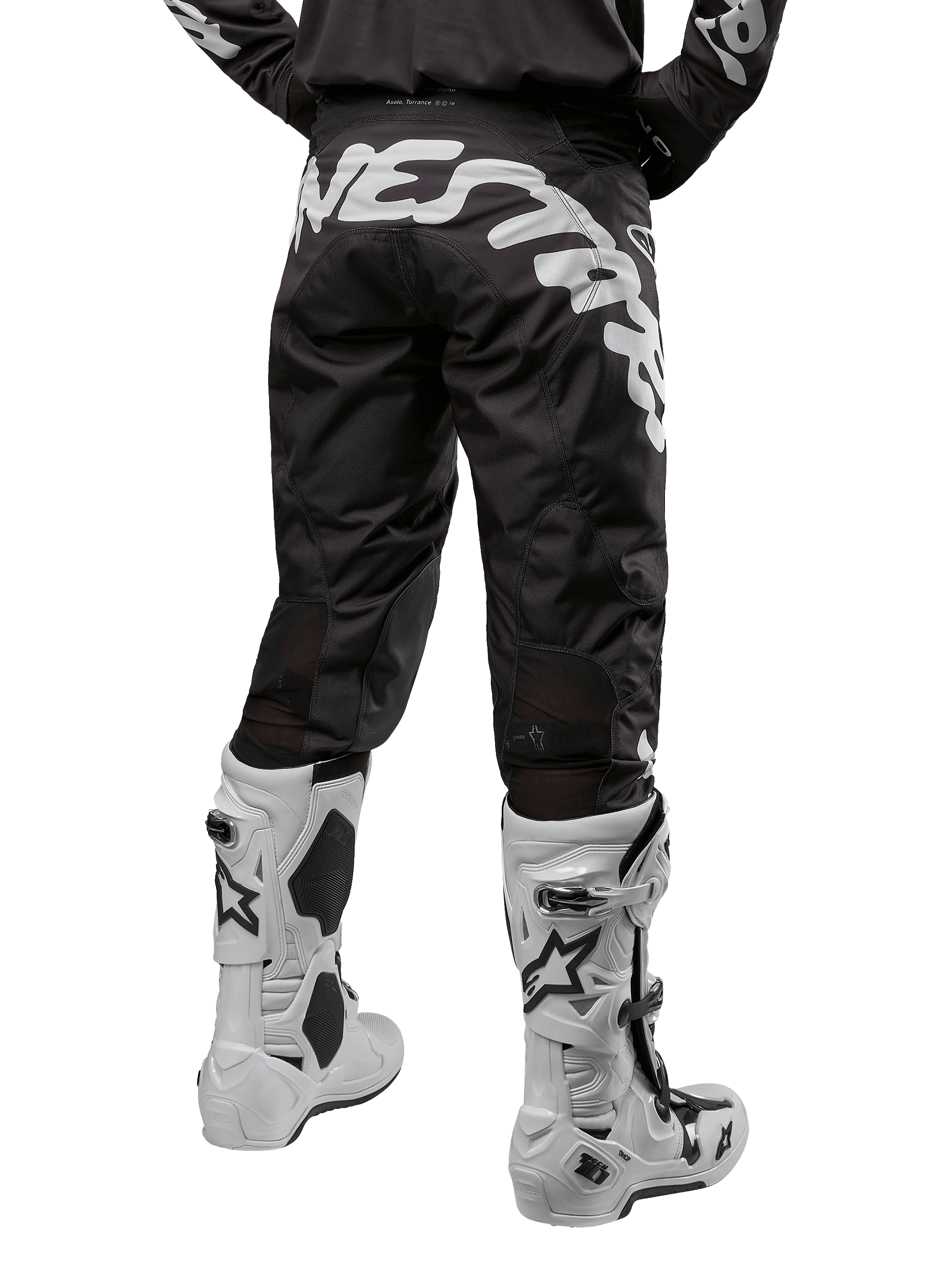 Alpinestars 2024 Racer Hana crossbroek, motorcross broek, zwart met grote witte grafische tekst op de achterzijde, achteraanzicht van een rijder met witte motorcrosslaarzen, duurzaam en technisch materiaal voor off-road rijden