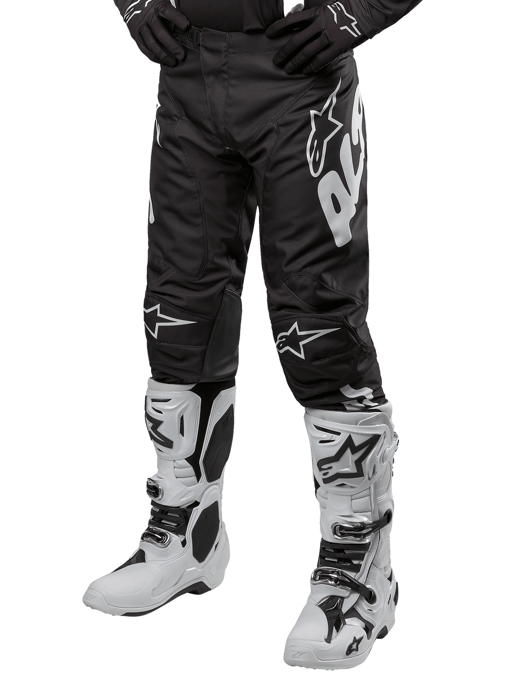 Alpinestars 2024 Racer Hana Pants, motorcross broek, zwart met witte Alpinestars logo's, sportieve pasvorm, gedragen met witte motorlaarzen en zwarte handschoenen, off-road motoruitrusting